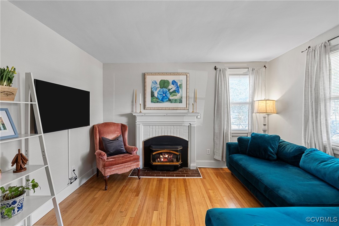 Living room, wood floors,  and a brick gas firepla