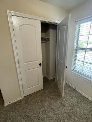 an empty room with windows and closet