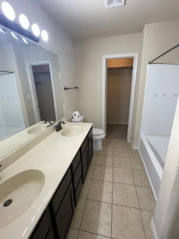 an empty room with a chandelier fan and windows