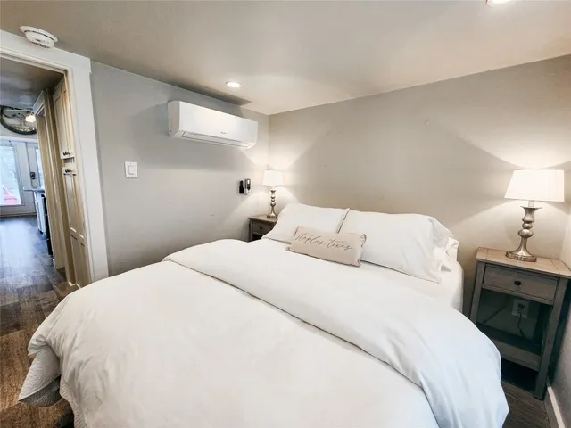 a spacious bedroom with two beds and a view of kitchen