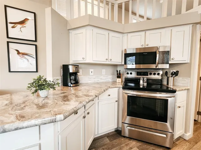 a kitchen with stainless steel appliances granite countertop a stove a sink and a microwave