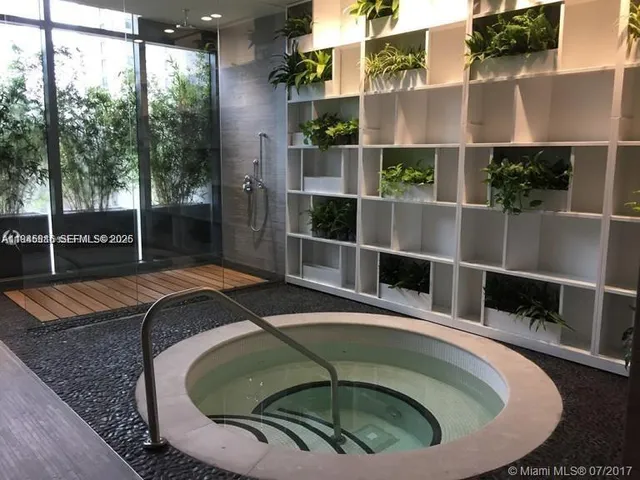 a living room with furniture floor to ceiling window and projector