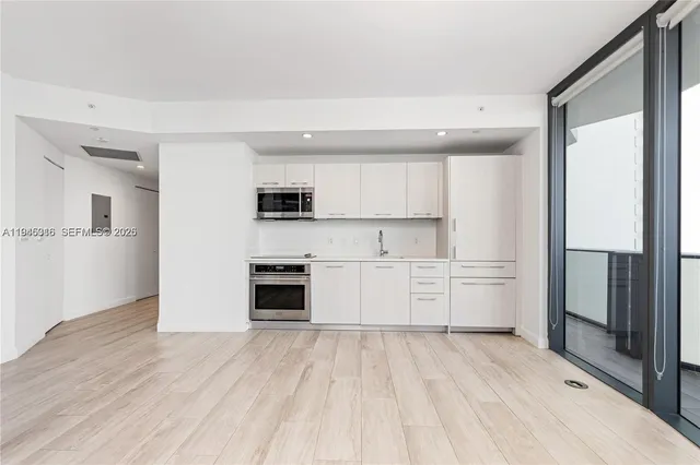 a kitchen with white cabinets and appliances