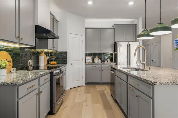 a kitchen with stainless steel appliances granite countertop a sink stove and refrigerator