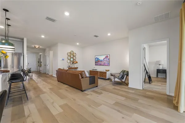 a living room with furniture a wooden floor and a chandelier