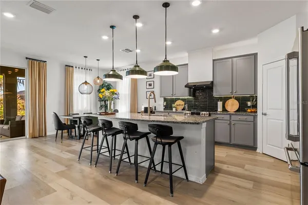 a dining room filled chandelier and wooden floor