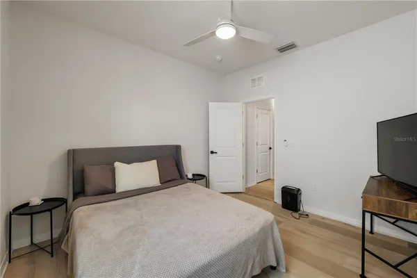 a bedroom with a bed and a flat tv screen on wall