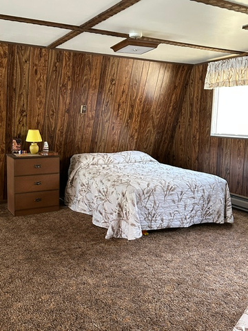 1085 West Elk Road Helper, UT 84526 - Photo 21 of 40 Room featuring wood-finish paneling, a textured ceiling with exposed beams, and a flush-mount ceiling light
