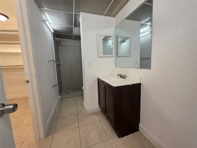 a bathroom with a sink a mirror and a shower
