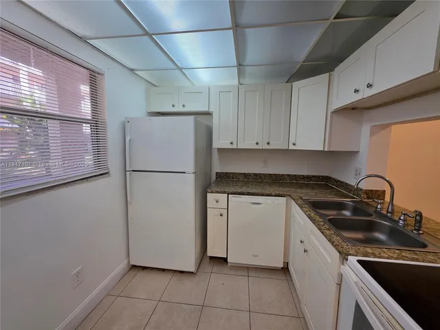 a kitchen with a refrigerator sink and cabinets