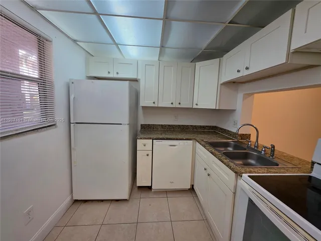 a kitchen with a refrigerator and a sink