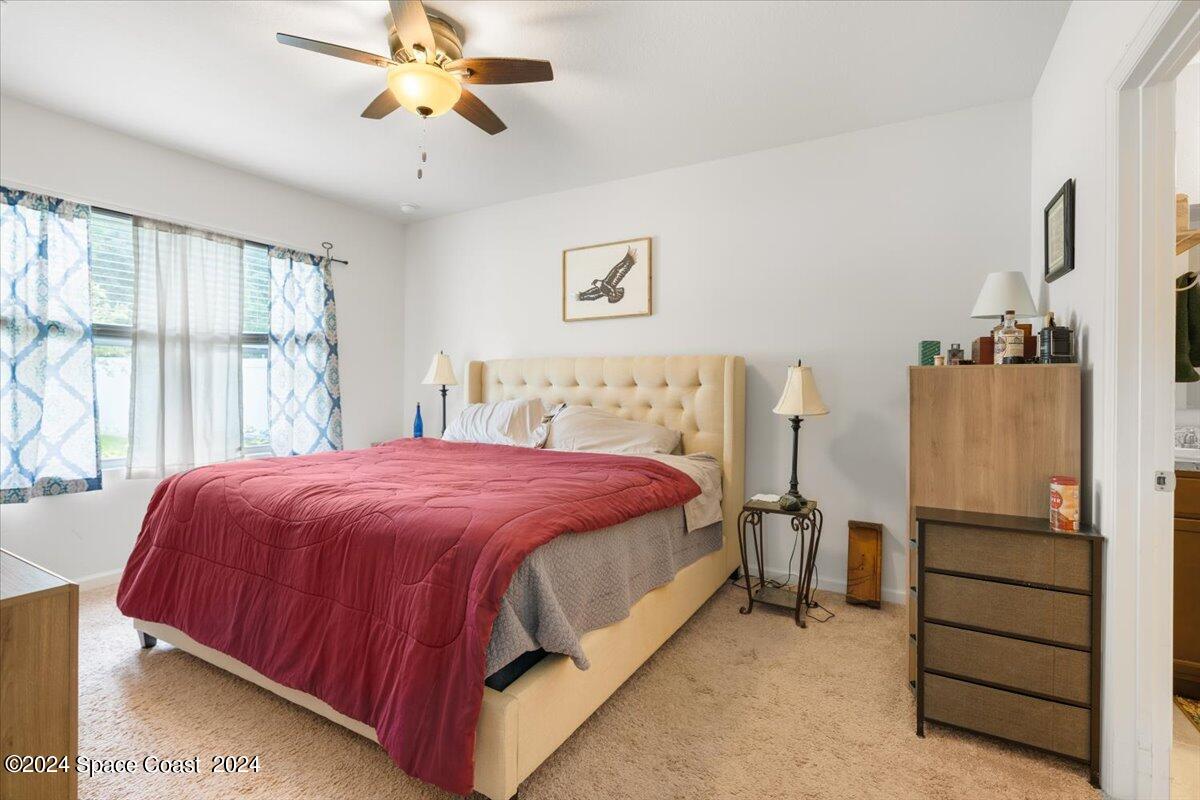 4332 Starling Place Mims, FL 32754 - Photo 12 of 28 a bedroom with a bed and a chandelier
