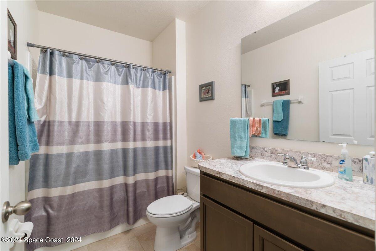 4332 Starling Place Mims, FL 32754 - Photo 18 of 28 a bathroom with a granite countertop sink toilet and shower