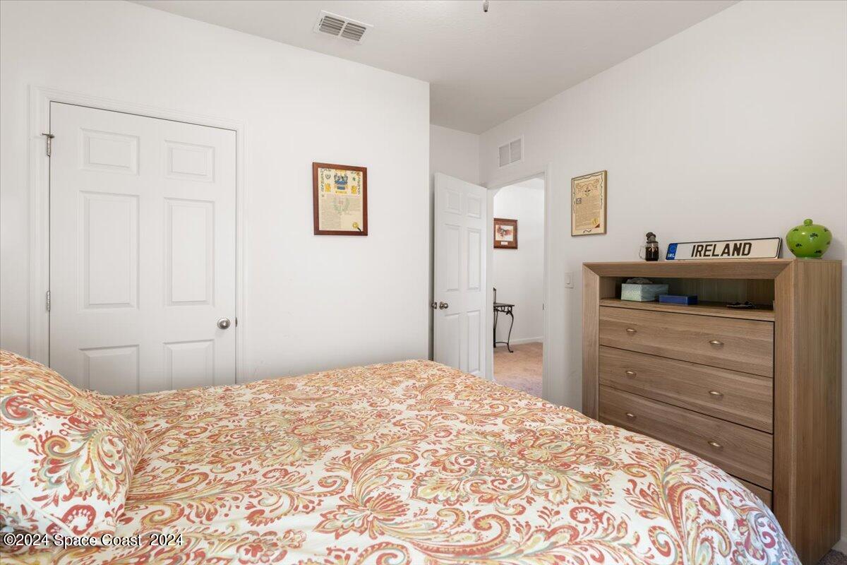 4332 Starling Place Mims, FL 32754 - Photo 20 of 28 a bedroom with a bed and a dresser