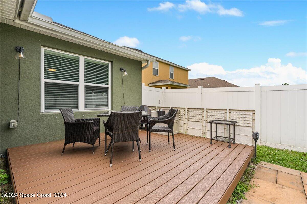 4332 Starling Place Mims, FL 32754 - Photo 22 of 28 a view of a roof deck with table and chairs floor to ceiling window with wooden floor