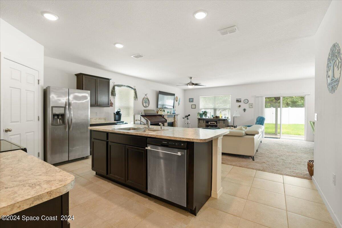 4332 Starling Place Mims, FL 32754 - Photo 4 of 28 a kitchen with stainless steel appliances granite countertop a sink and a refrigerator
