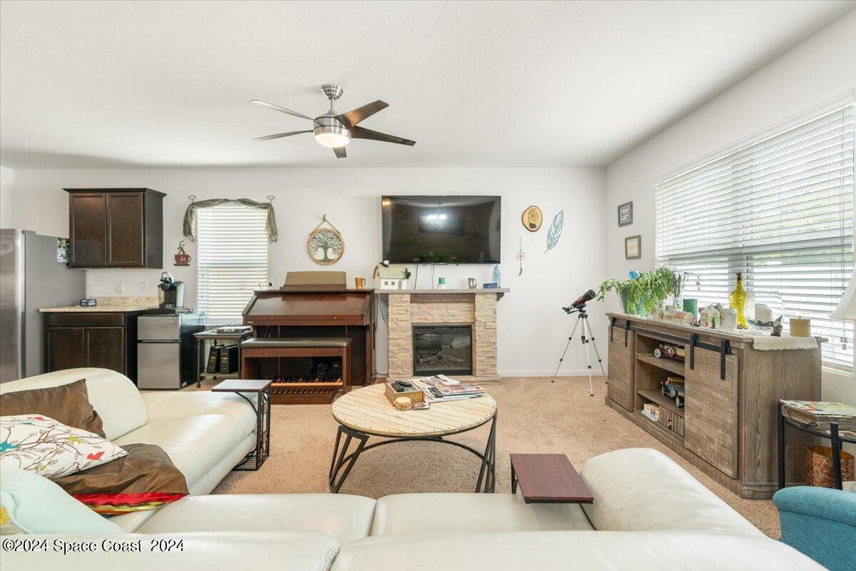 4332 Starling Place Mims, FL 32754 - Photo 9 of 28 a living room with furniture a flat screen tv and a fireplace