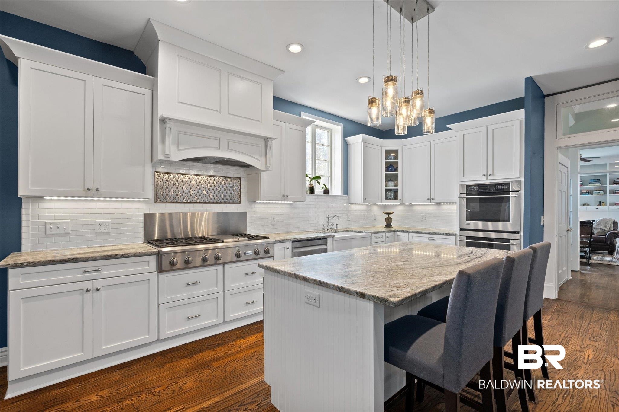 1953 Dauphin Street Mobile, AL 36606 - Photo 12 of 56 Kitchen featuring dark hardwood / wood-style flooring, a kitchen island, appliances with stainless steel finishes, and white cabinets