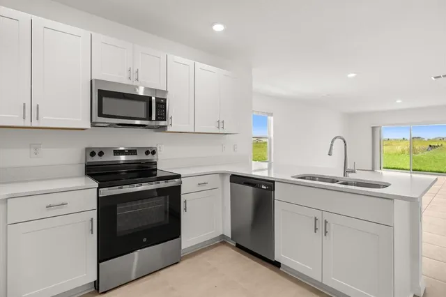 a kitchen with white cabinets and stainless steel appliances