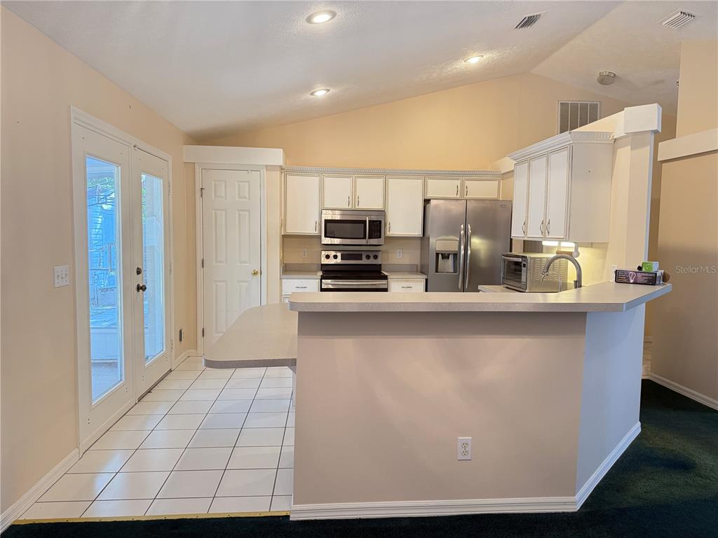 4262 Northeast 35th Avenue Road Ocala, FL 34479 - Photo 3 of 25 a kitchen with stainless steel appliances a refrigerator and a stove