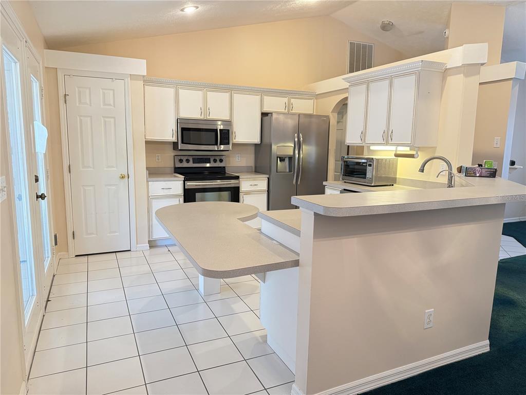 4262 Northeast 35th Avenue Road Ocala, FL 34479 - Photo 4 of 25 a kitchen with stainless steel appliances a sink a stove a microwave a refrigerator and cabinets