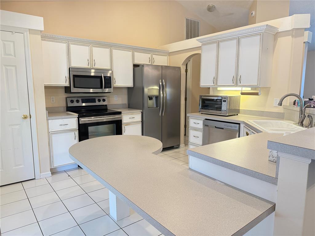 4262 Northeast 35th Avenue Road Ocala, FL 34479 - Photo 5 of 25 a kitchen with stainless steel appliances a refrigerator stove microwave and sink