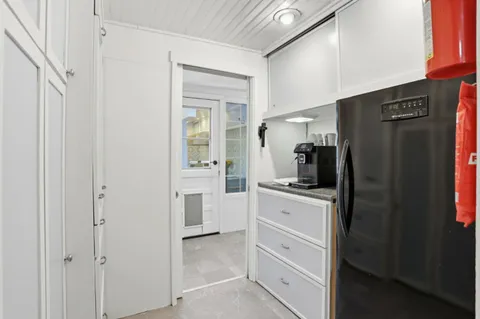 a kitchen with white cabinets and refrigerator