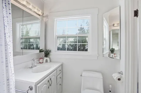 a bathroom with a sink a toilet and a window