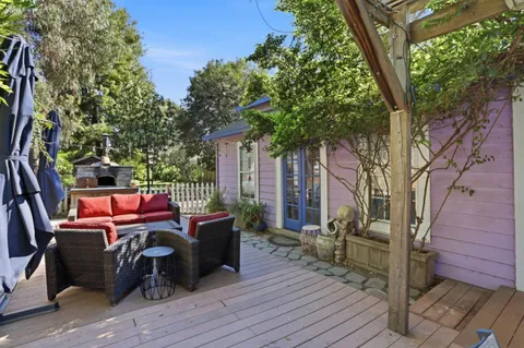 a view of a roof deck with couches fire pit and wooden fence