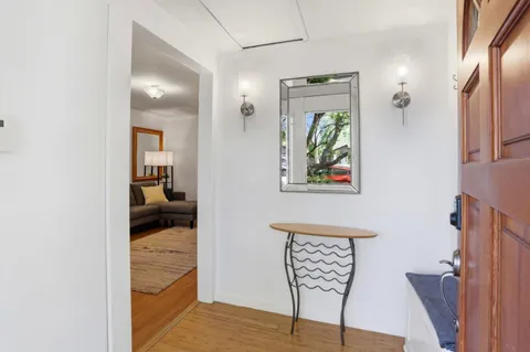 a view of a hallway to a livingroom and a dining room with furniture