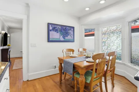 a dining room with furniture and wooden floor