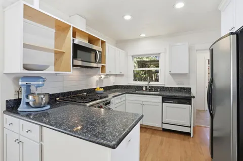 a kitchen with stainless steel appliances granite countertop a sink stove and microwave