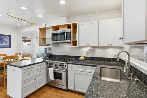 a kitchen with stainless steel appliances granite countertop a stove sink and cabinets
