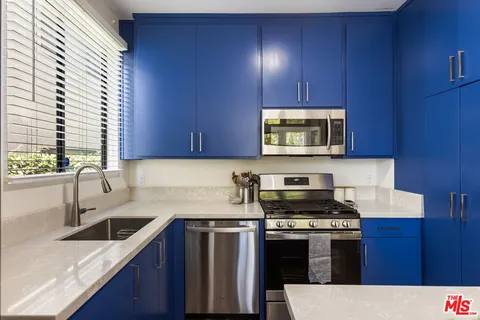 a kitchen with stainless steel appliances wooden cabinets and a stove top oven