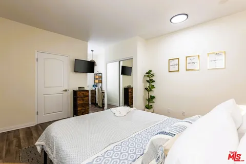 a bedroom with a bed and a flat screen tv