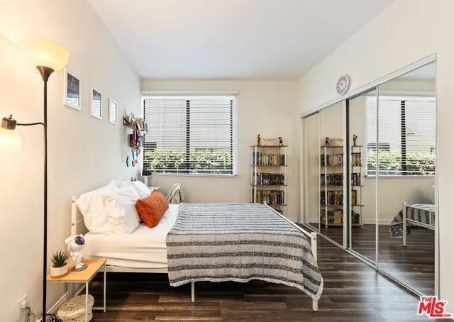 a bedroom with a bed and large windows