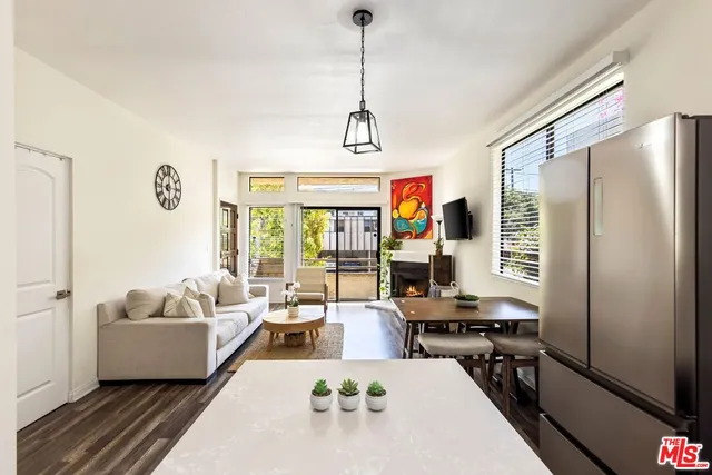a living room with furniture flat screen tv and a large window