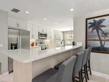 a large kitchen with stainless steel appliances lots of counter space and a refrigerator