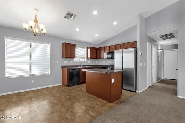 a large kitchen with a refrigerator and a stove top oven