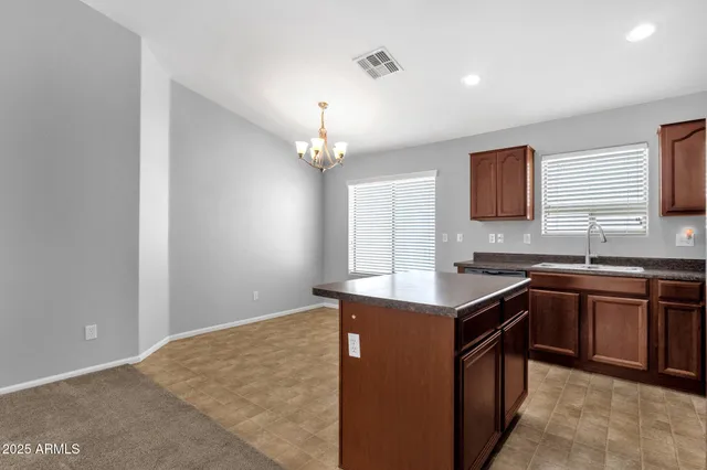a kitchen with kitchen island granite countertop a sink stove and cabinets
