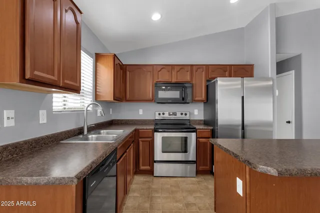 a kitchen with granite countertop a sink stove and refrigerator