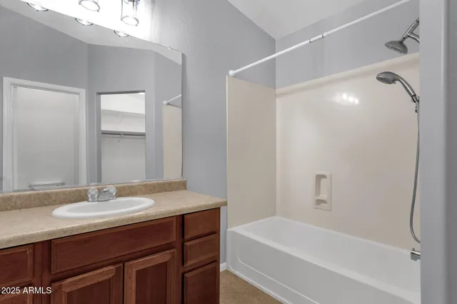 a bathroom with a granite countertop sink a mirror and a bathtub