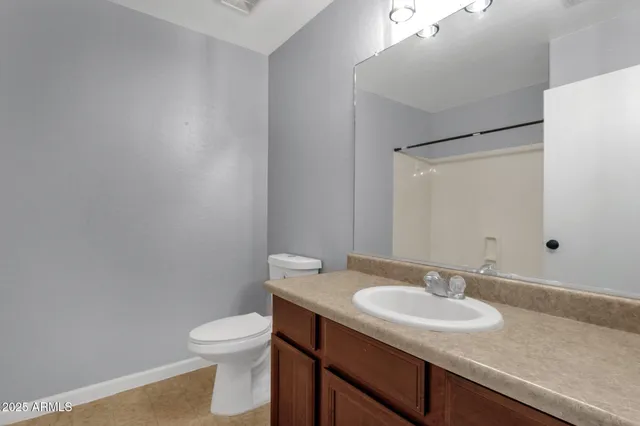a bathroom with a granite countertop sink toilet and a mirror