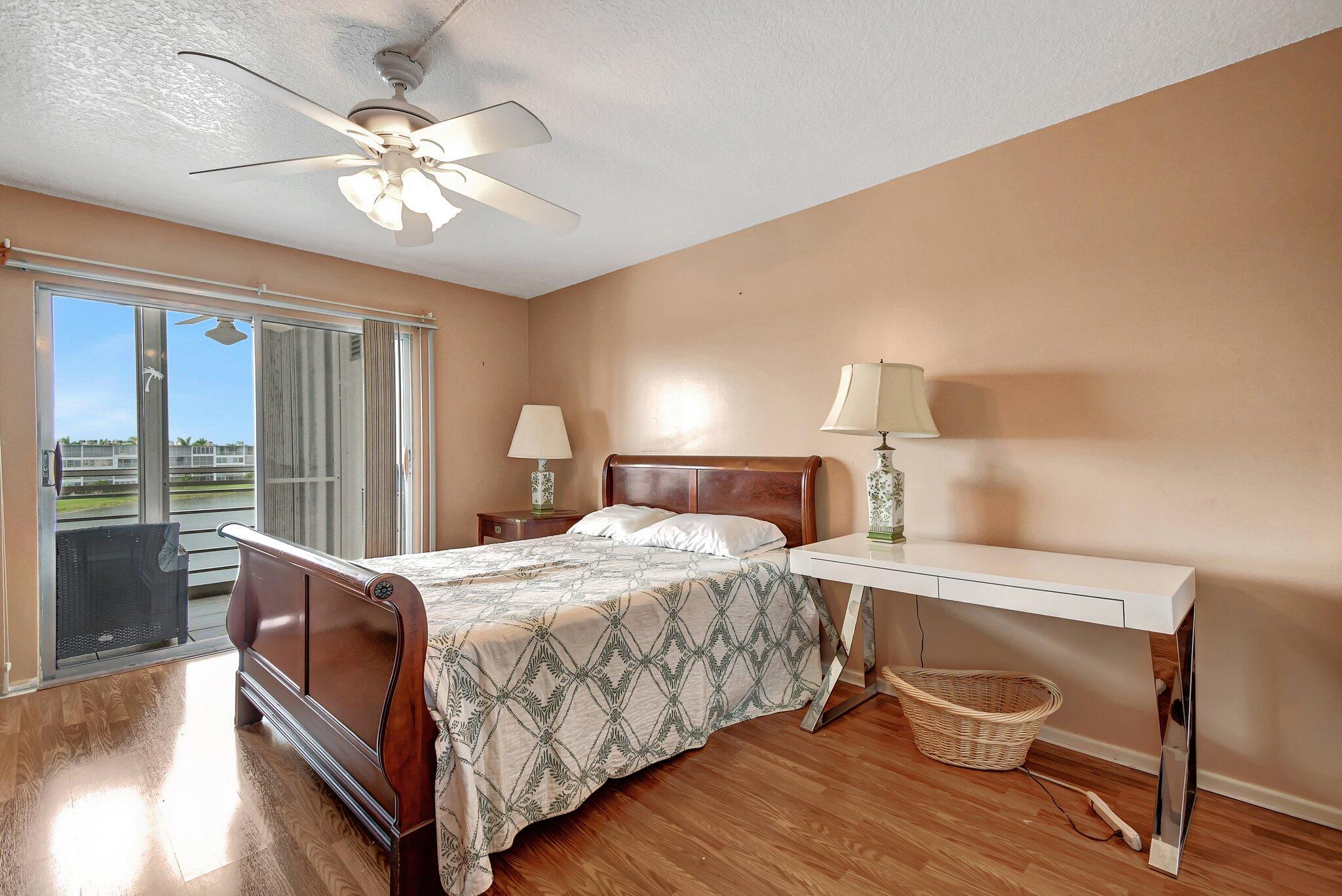 4089 Guildford East, Unit E Boca Raton, FL 33434 - Photo 18 of 22 a bedroom with a bed and a chandelier