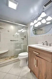 a bathroom with a sink a toilet and shower