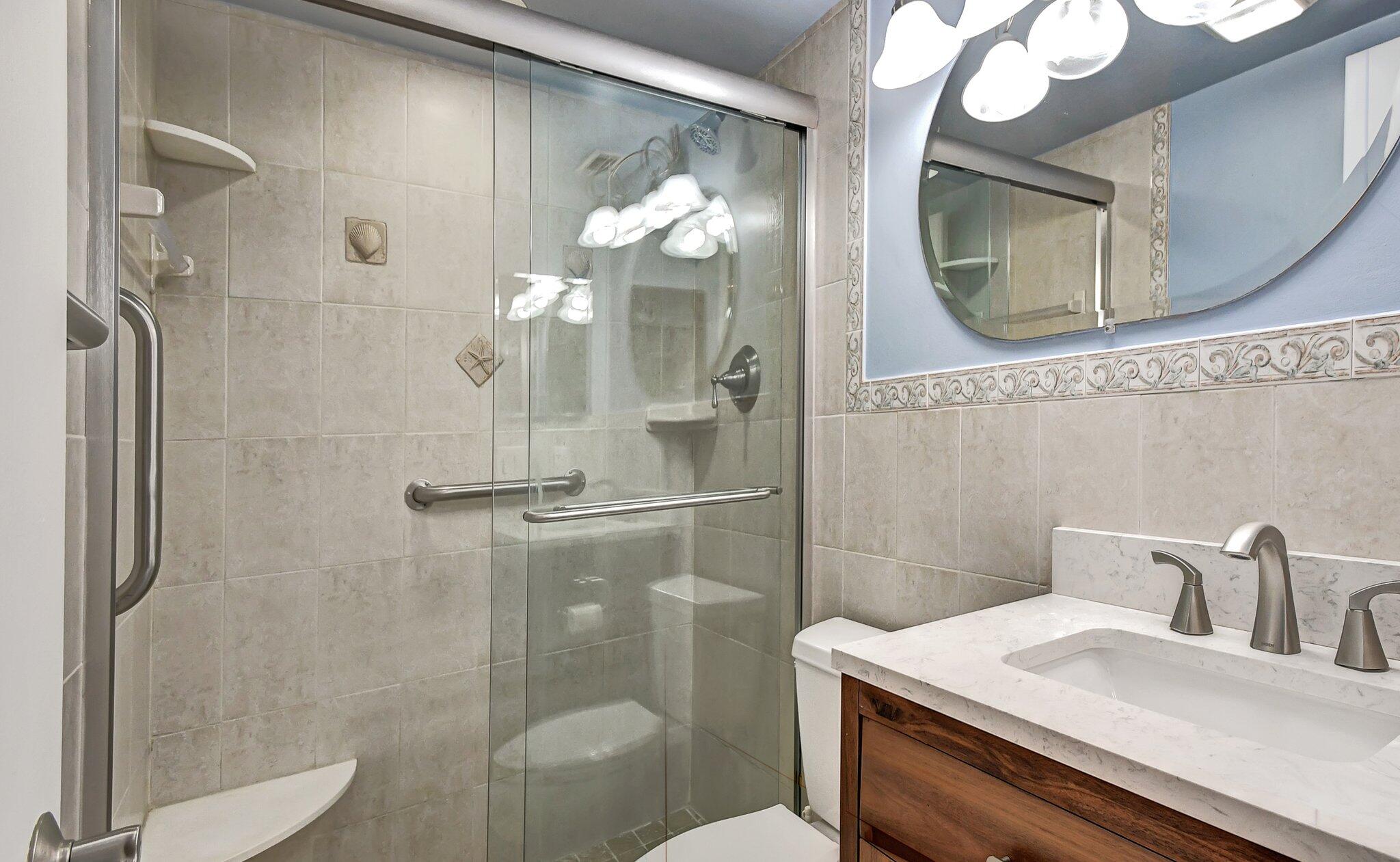 4089 Guildford East, Unit E Boca Raton, FL 33434 - Photo 20 of 22 a bathroom with a sink a toilet and a mirror