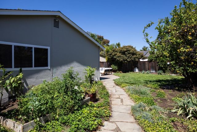 a front view of a house with a yard and potted plants