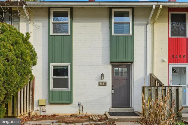 a front view of a house with a green gate