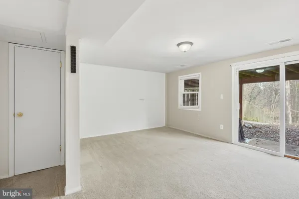 an empty room with sliding door and wooden floor