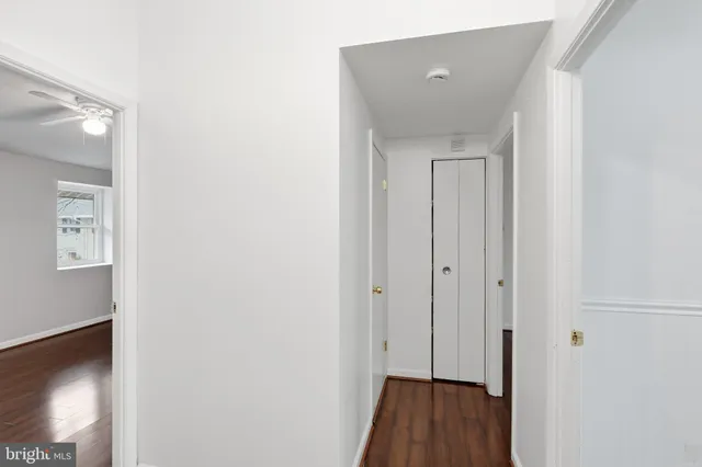 a view of a hallway with wooden floor and closet